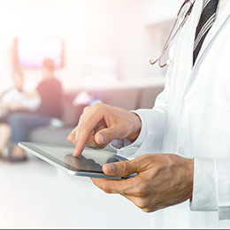 Doctor works on patient chart with tablet.